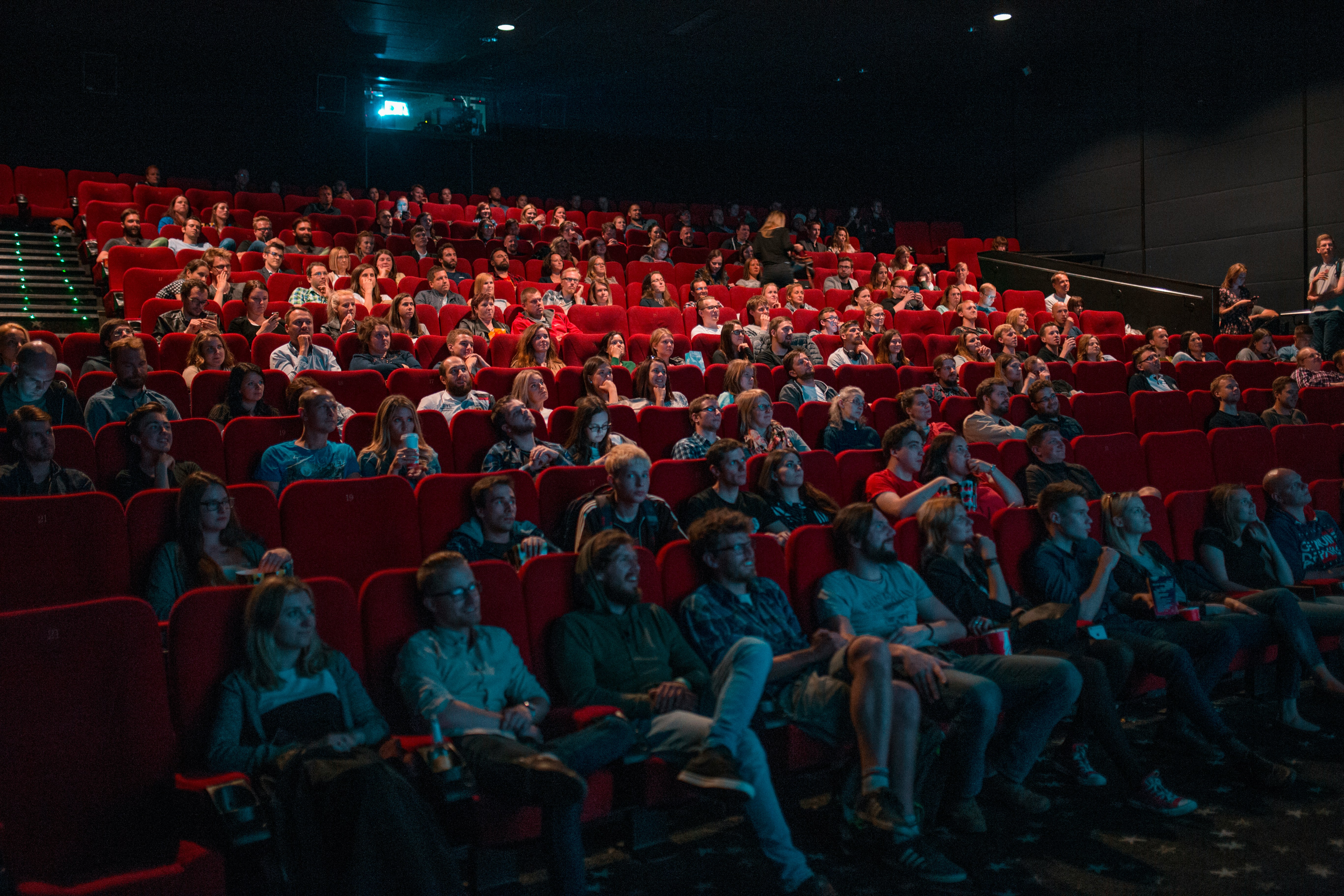 Crowded cinema room with people watching a movie