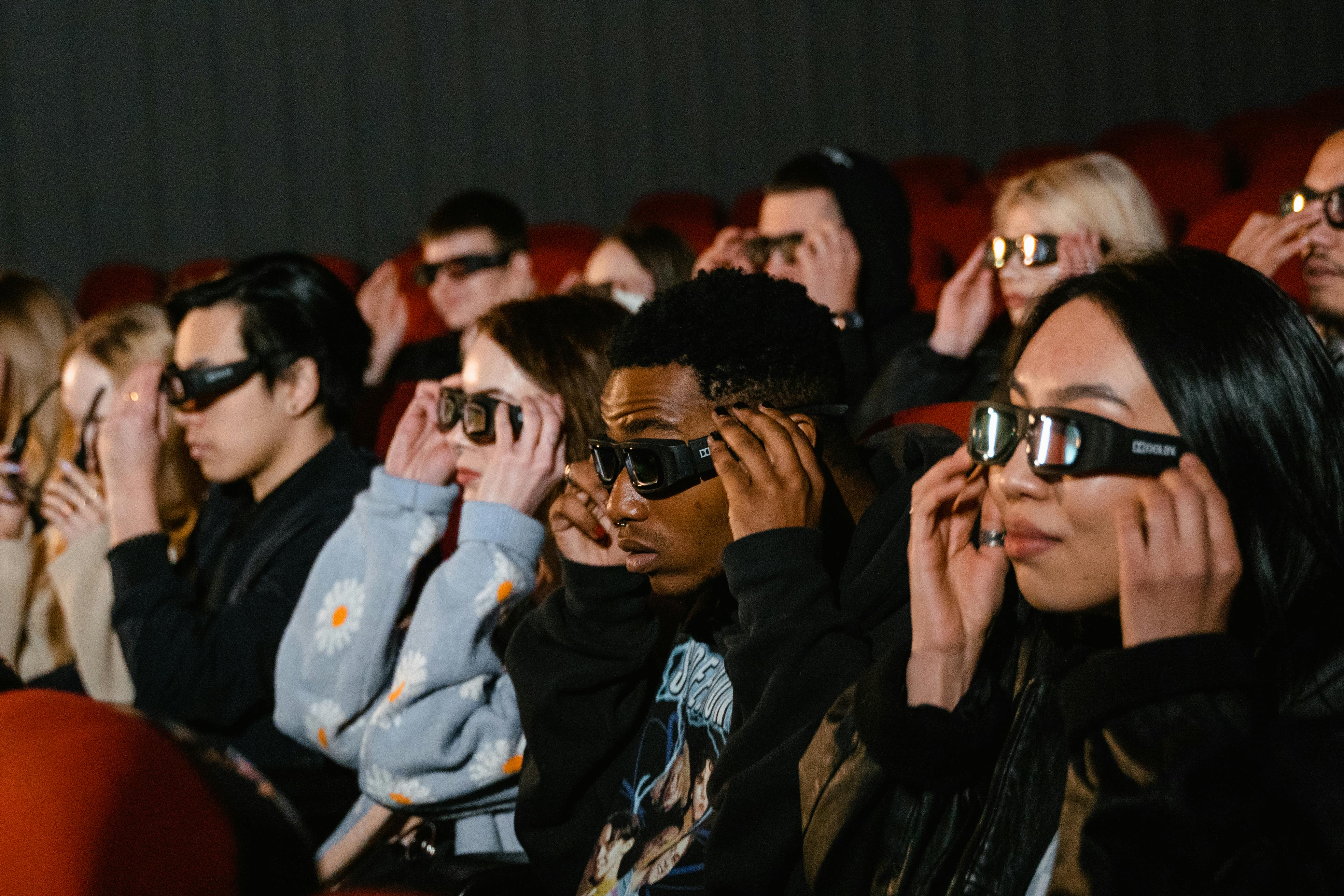 Bunch of teens and young adults with 3D glasses on their heads in a cinema room